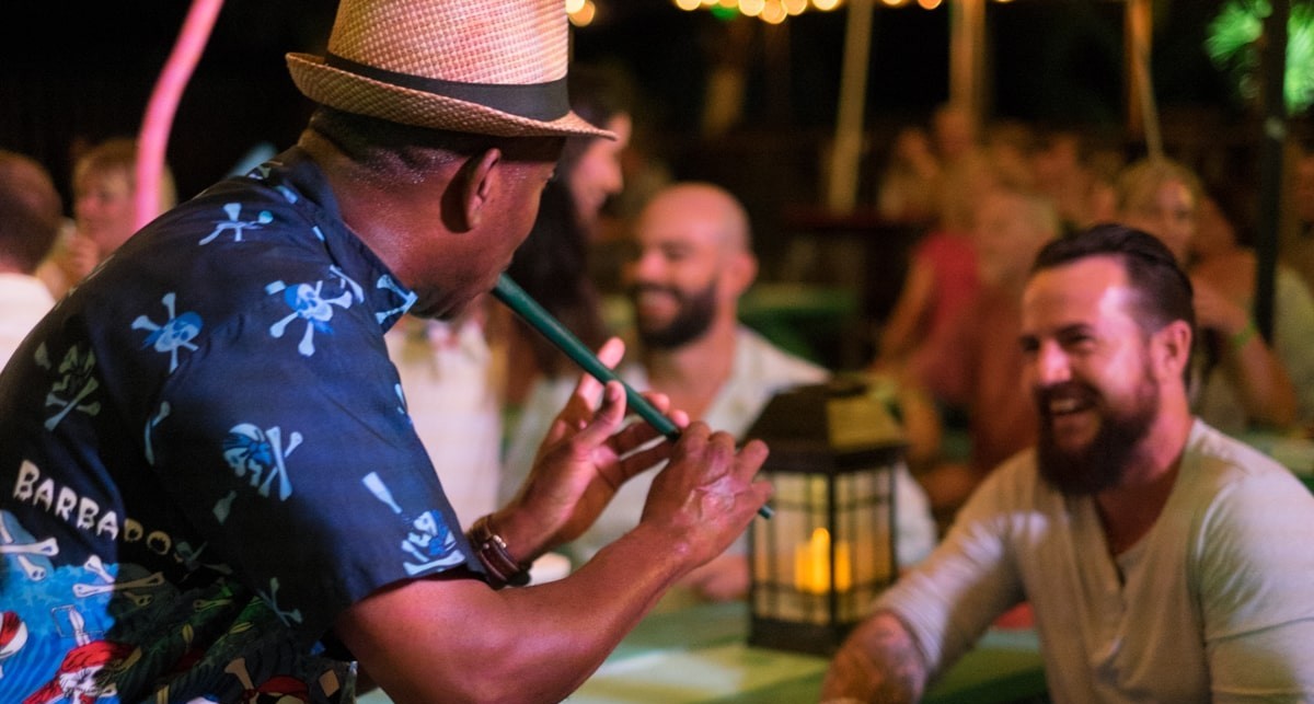 man playing instrument in front of people